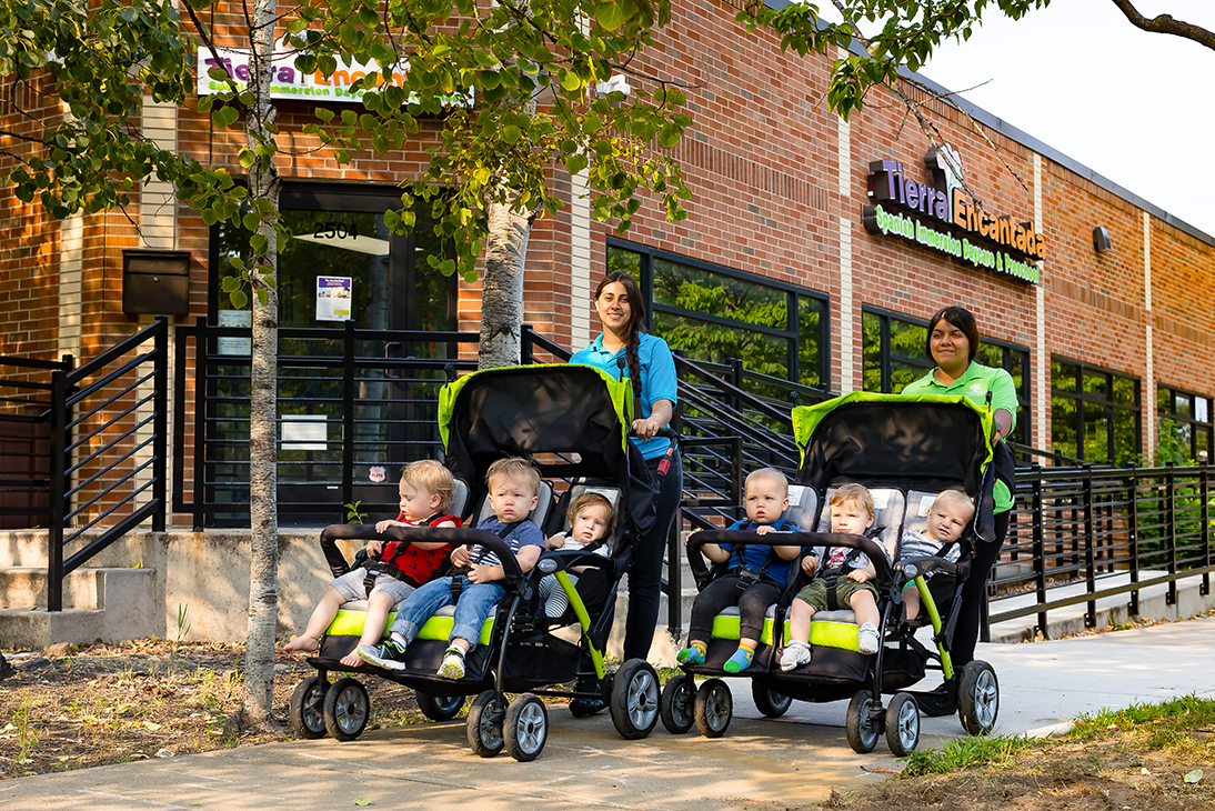 woman walking with a stroller and children